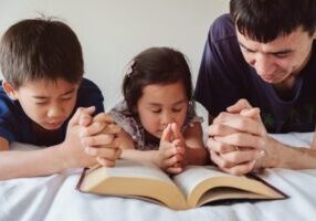 Father praying with children