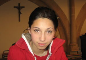 Brunette girl in a church crucifix and column in the background ** Note: Slight blurriness, best at smaller sizes